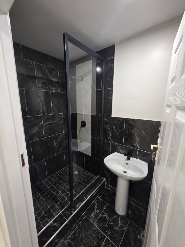 Greys Inn bathroom with a basin, toilet and glass-enclosed shower