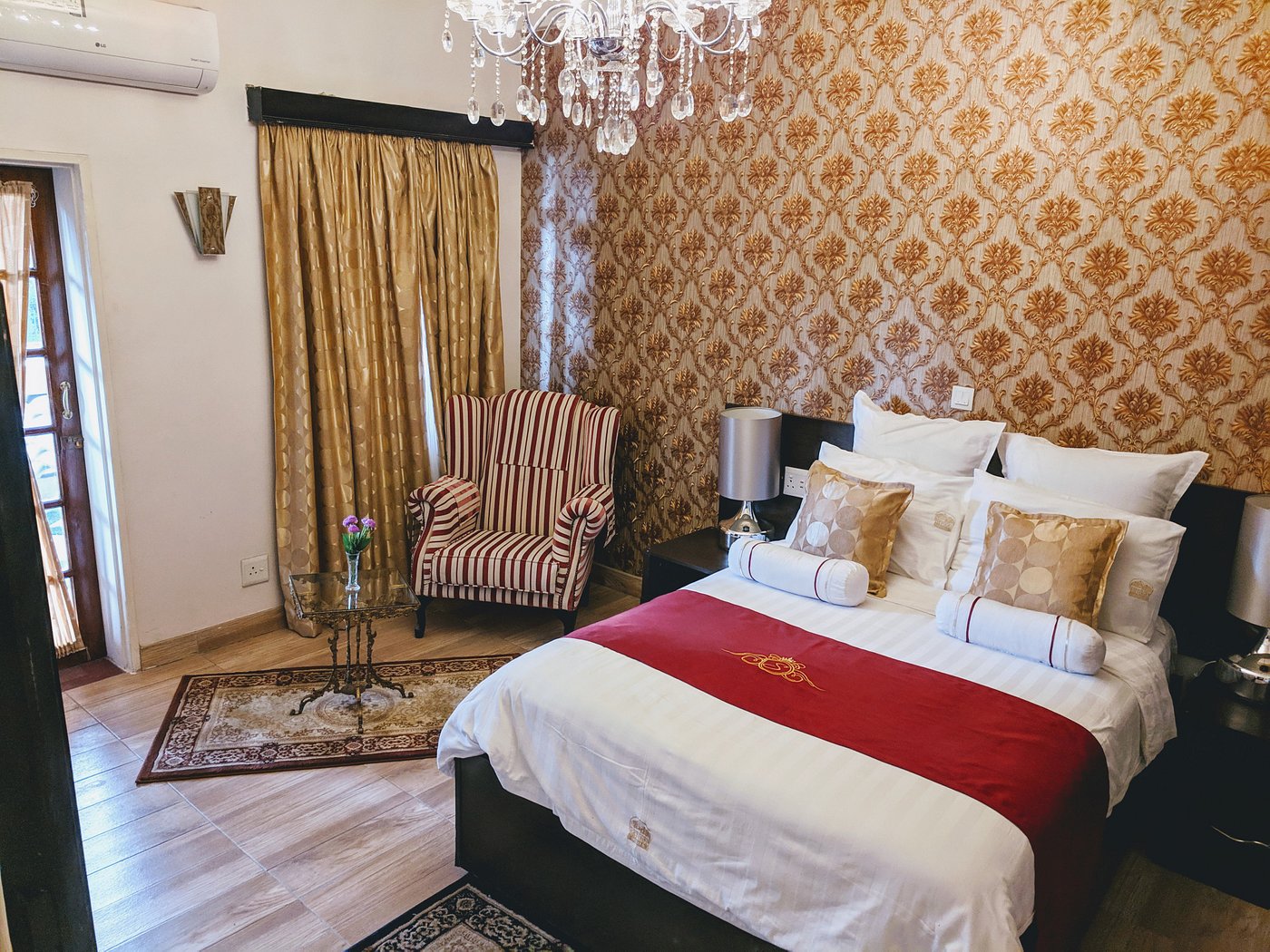 Selborne guest room with white bedding, gold furnishings and burgundy accents